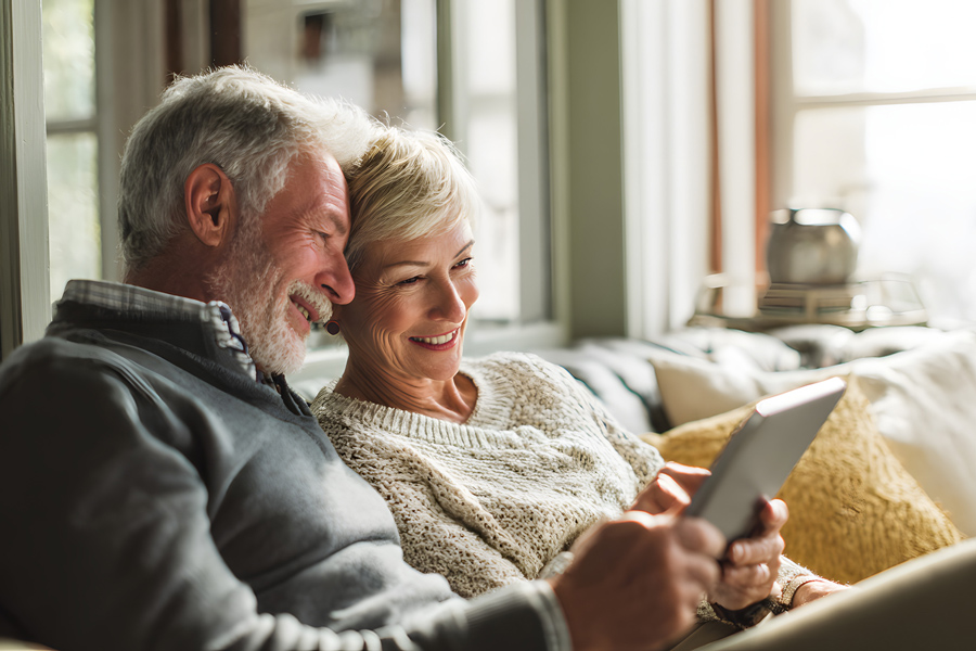 Senior couple on tablet together at home reviewing their pension and retirement income